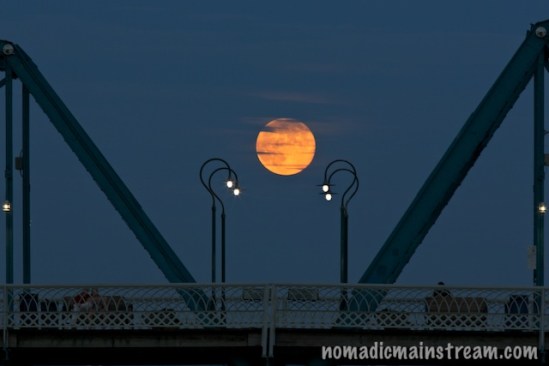 The rising full moon pauses over Walnut Street Bridge