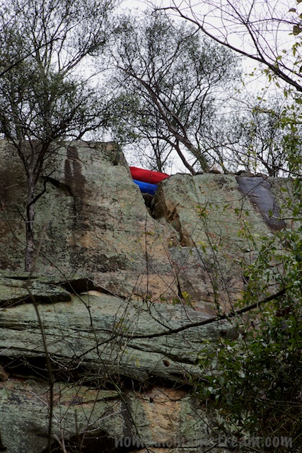 Two hammocks visible from the trail below the cliff